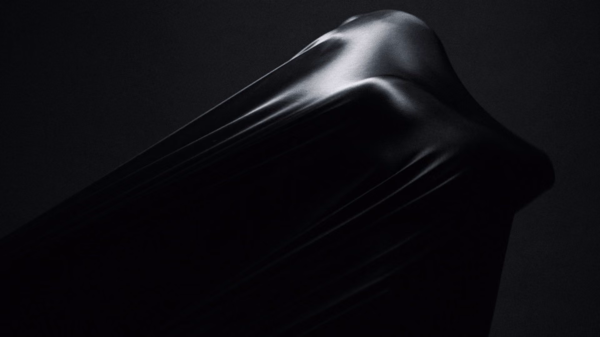 Forma drapeada negra y brillante sobre fondo negro