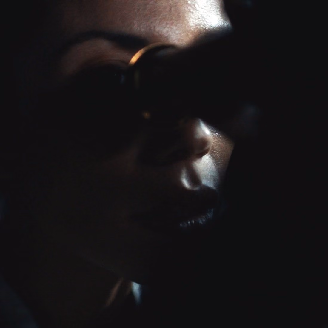 Encuadre oscuro con un filo de luz sobre un rostro