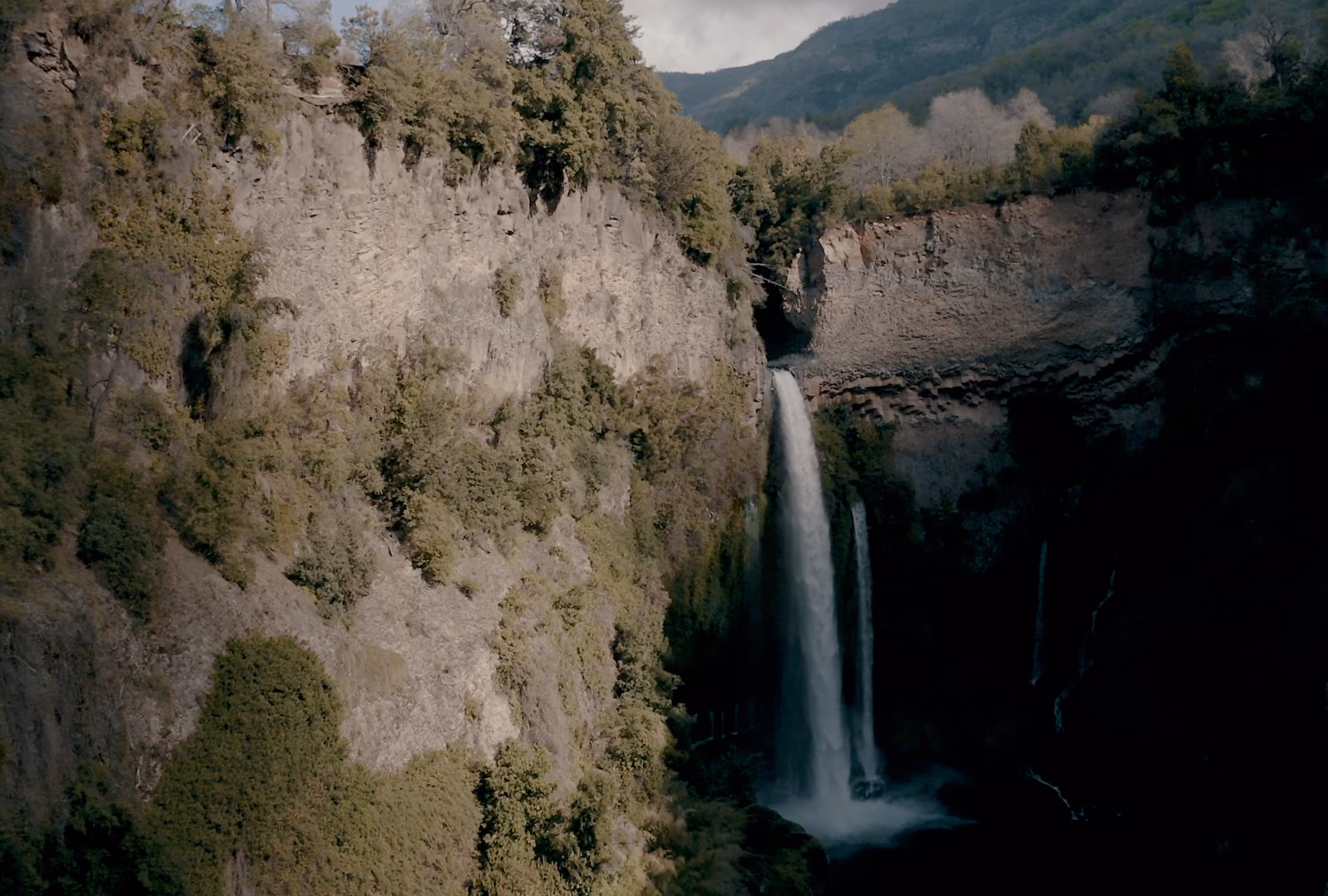 Cascada en un cañón rocoso rodeado de vegetación