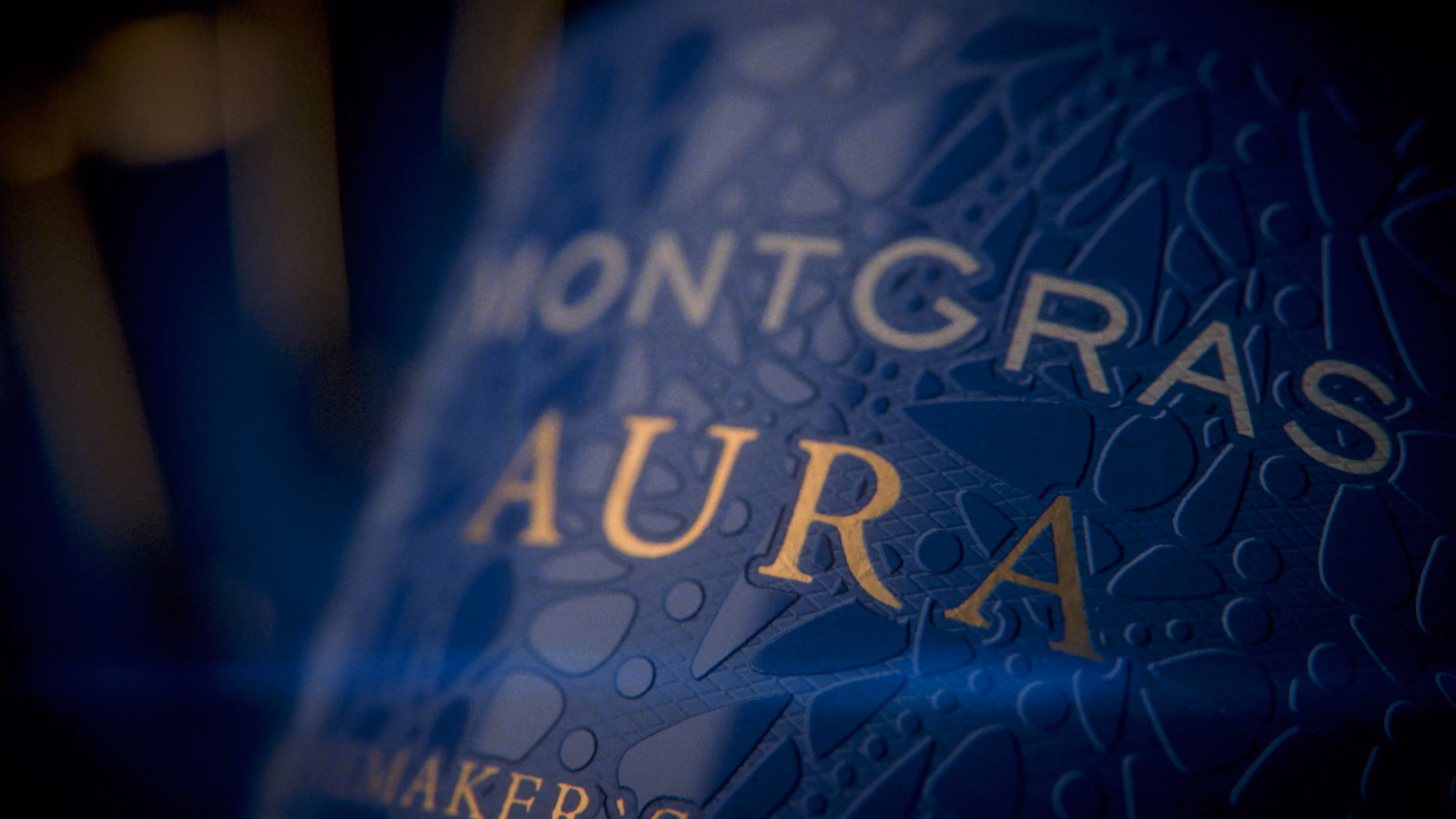 Etiqueta de la botella MontGras Aura en azul profundo y dorado