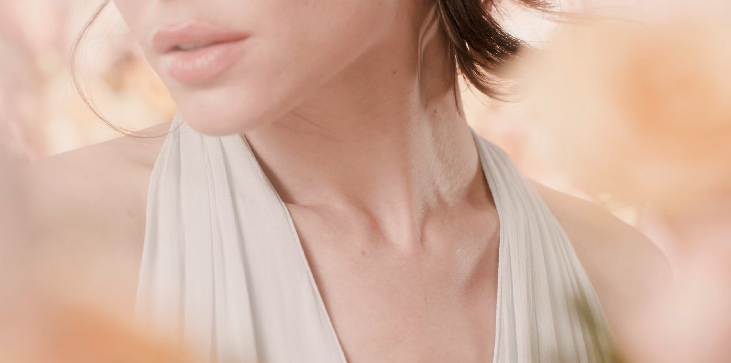 Detalle de cuello y clavícula sobre tela blanca